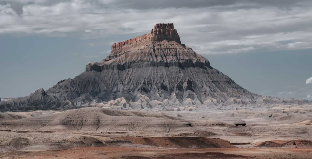 Factory Butte in the Blue Hills in Utah under an atmospheric sky