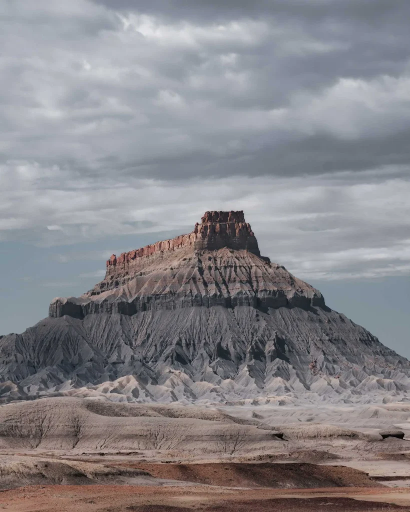 Factory Butte in the Blue Hills in Utah under an atmospheric sky